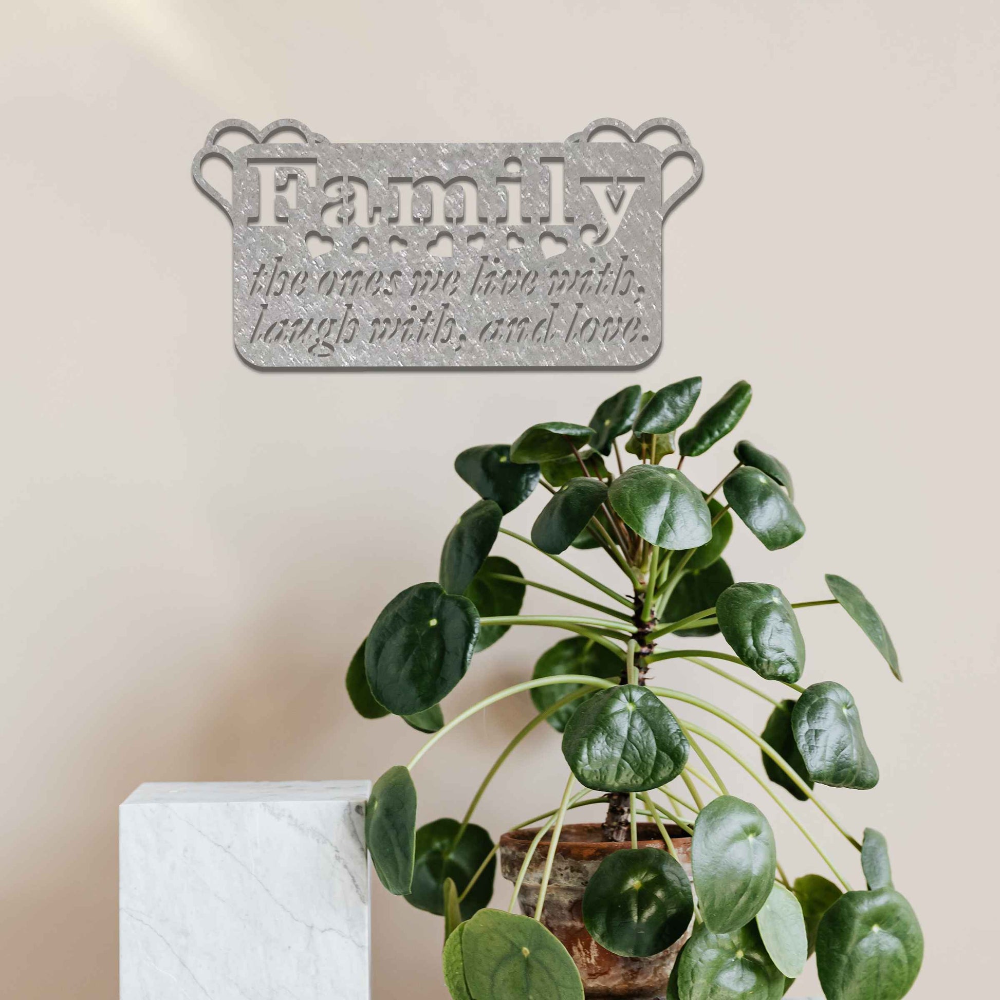 Metal wall decoration featuring the word "Family" and the phrase "the ones we live with, laugh with, and love," accented with heart details, adding a heartfelt and meaningful touch to indoor or outdoor spaces.