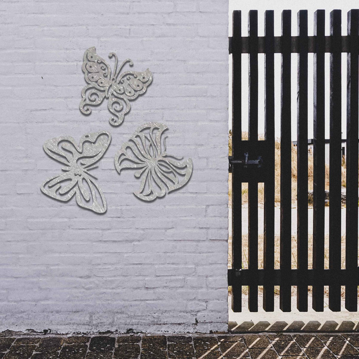 Set of metal garden decorations featuring three distinct butterfly designs with intricate patterns, adding a playful and nature-inspired charm to outdoor walls, fences, or garden spaces