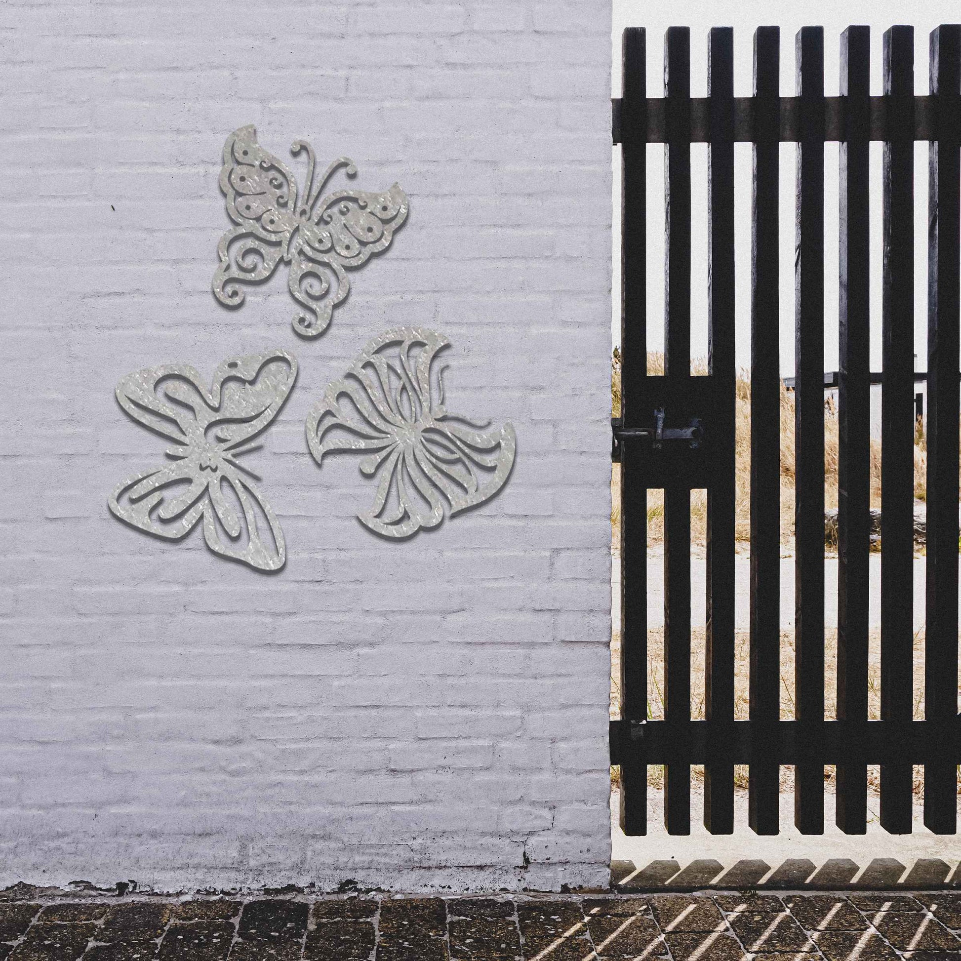 Set of metal garden decorations featuring three distinct butterfly designs with intricate patterns, adding a playful and nature-inspired charm to outdoor walls, fences, or garden spaces