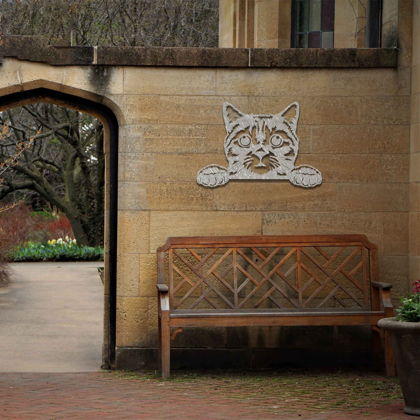 A charming metal wall art piece featuring an adorable cat peeking over a surface, its wide eyes and paws reaching out, adding a playful and endearing touch to modern home decor.