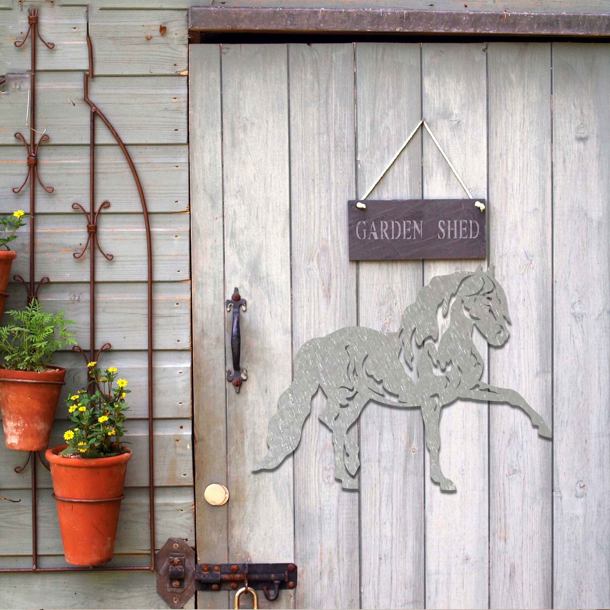 Metal wall art of a horse with a proud stance, featuring flowing mane and tail, captured in a dynamic pose. The design emphasizes strength and elegance, showcasing the horse's muscular form.