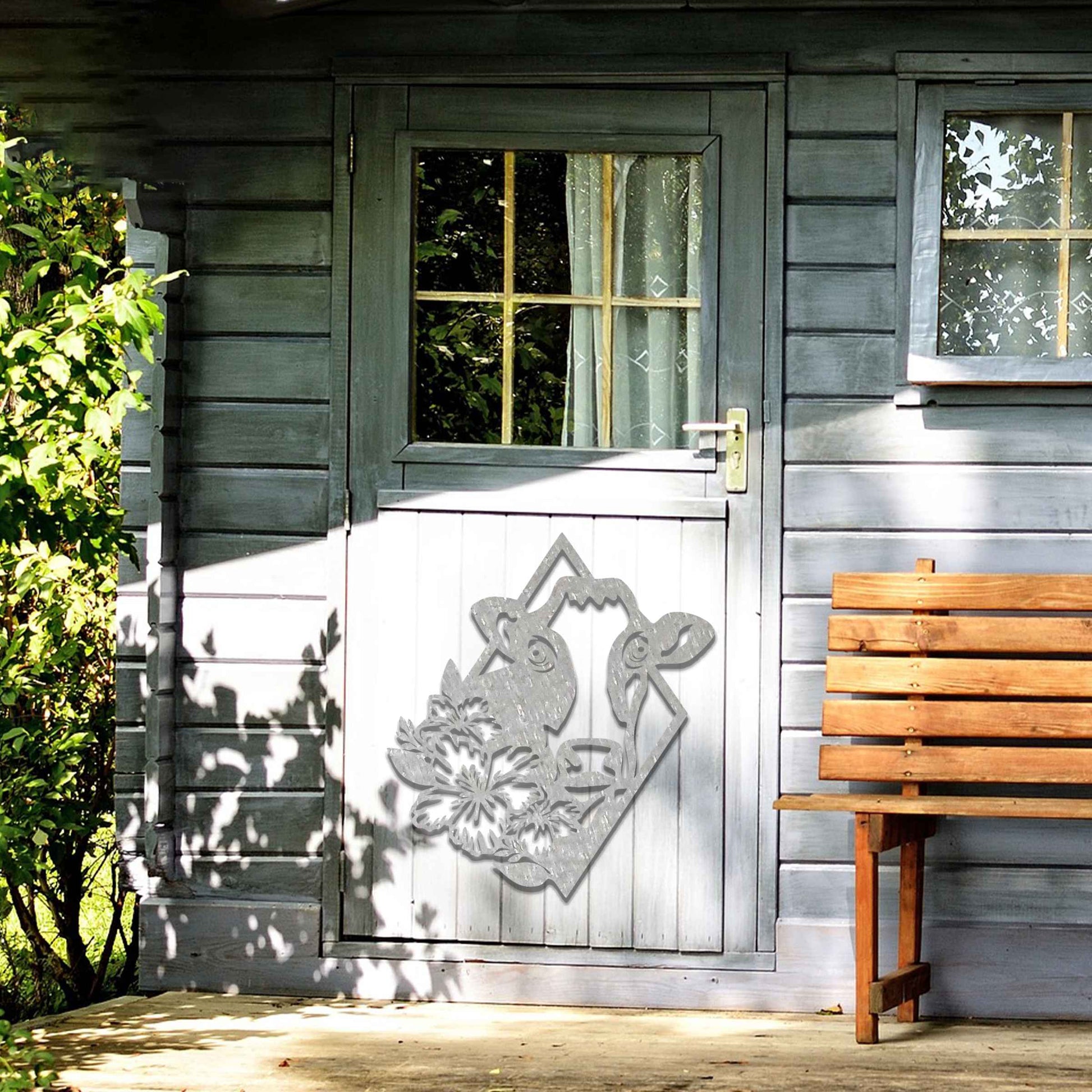 The design features a cow's face framed by a geometric shape, with flowers on its side, combining natural and abstract elements in a modern, stylized way.