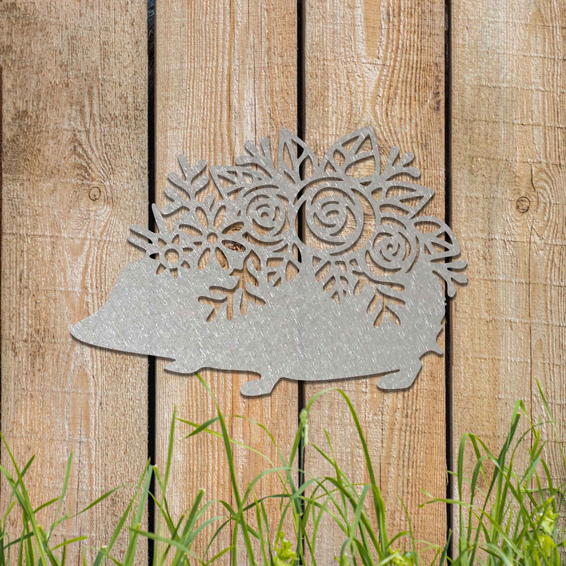 Metal garden decoration featuring a hedgehog-shaped design with intricate floral cutouts, adding a charming and rustic touch to outdoor spaces, perfectly blending with garden greenery.