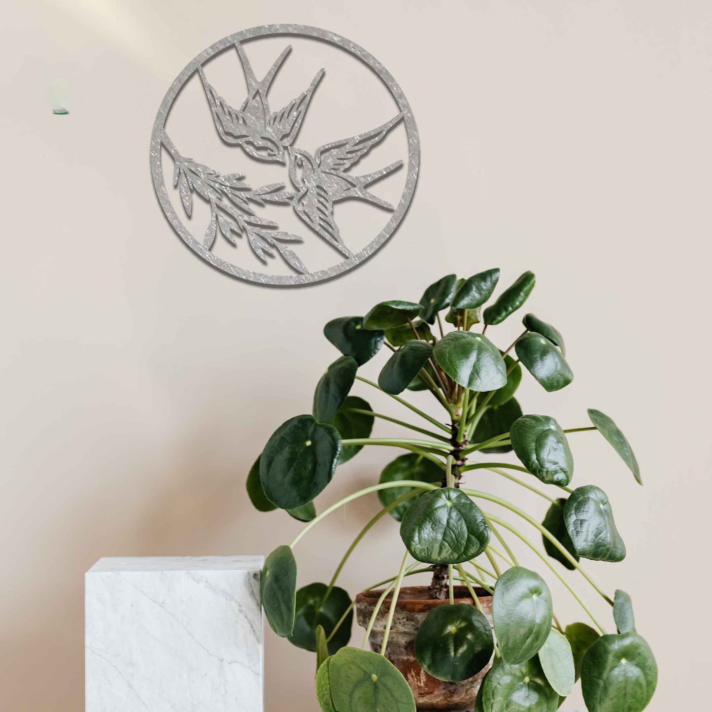 Metal garden decoration featuring two swallows in flight within a circular frame, accented by delicate branch details, combining nature-inspired elegance and craftsmanship to enhance outdoor or indoor spaces.