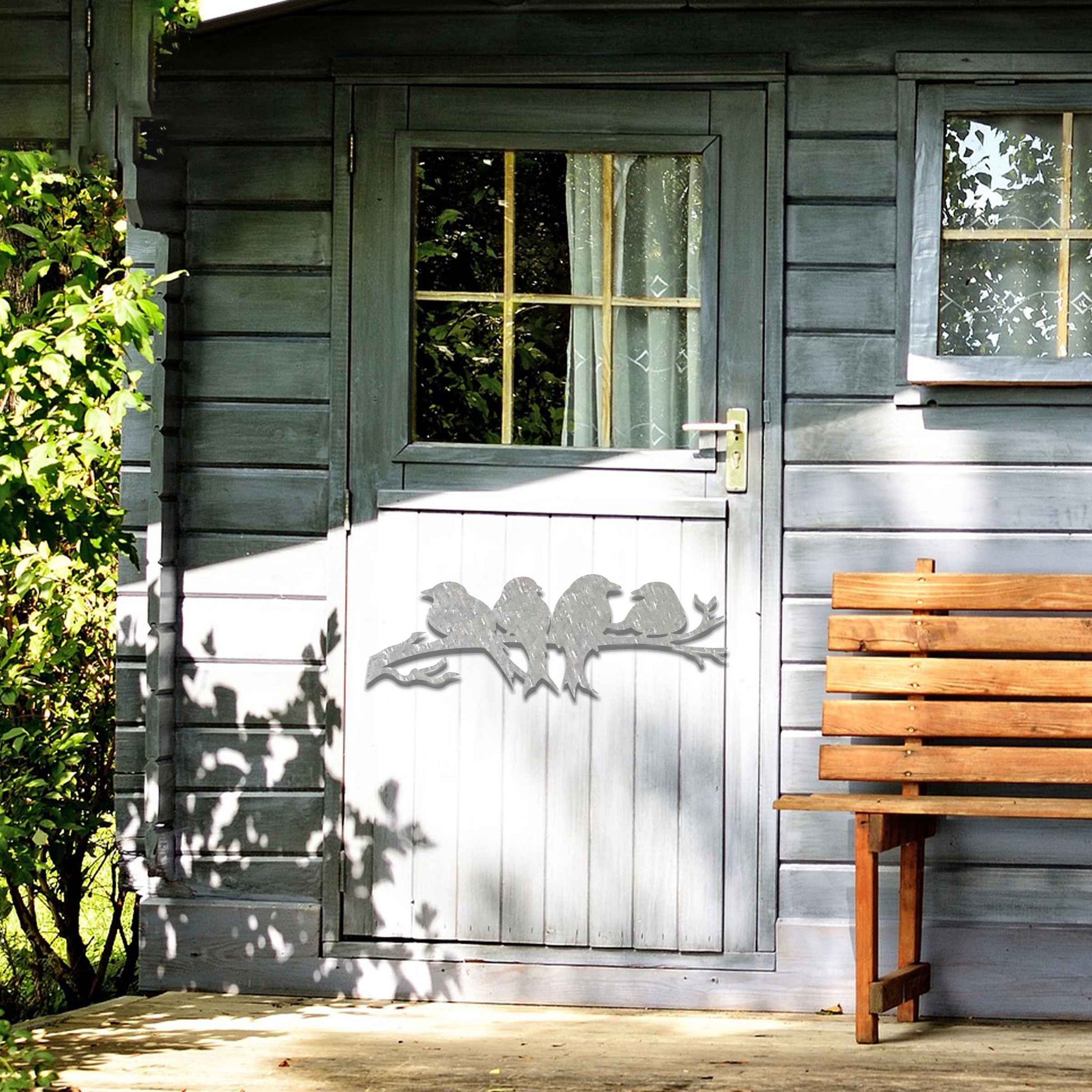Metal garden decoration featuring four birds sitting on a branch, crafted with intricate cutout details and a rustic finish, adding a delightful and natural charm to outdoor walls or garden spaces.