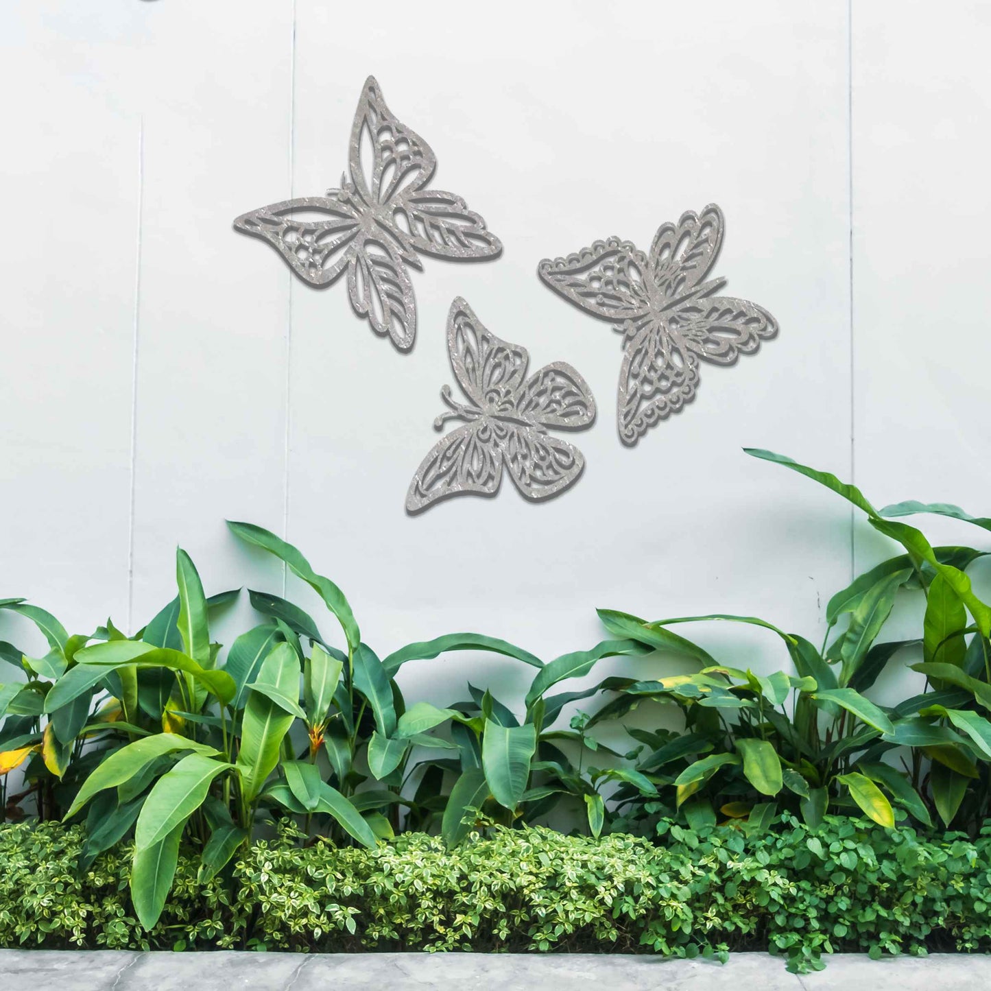 Set of metal garden decorations featuring three intricately designed butterflies with a rustic finish, adding a graceful and nature-inspired aesthetic to outdoor walls or garden spaces.