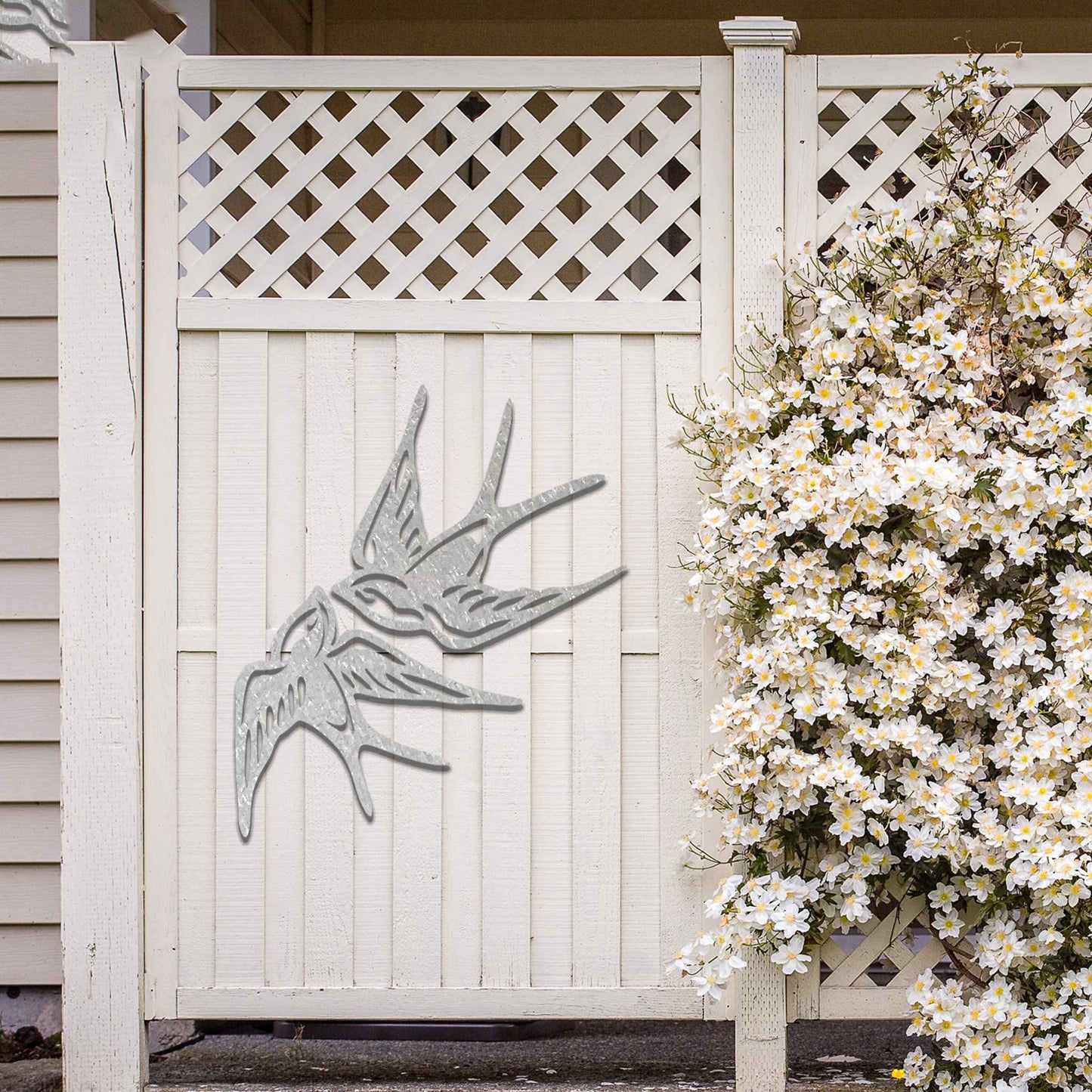 Metal garden decoration featuring a pair of swallows in flight, crafted with intricate detailing and a rustic finish, adding a graceful and timeless charm to outdoor walls or garden spaces.