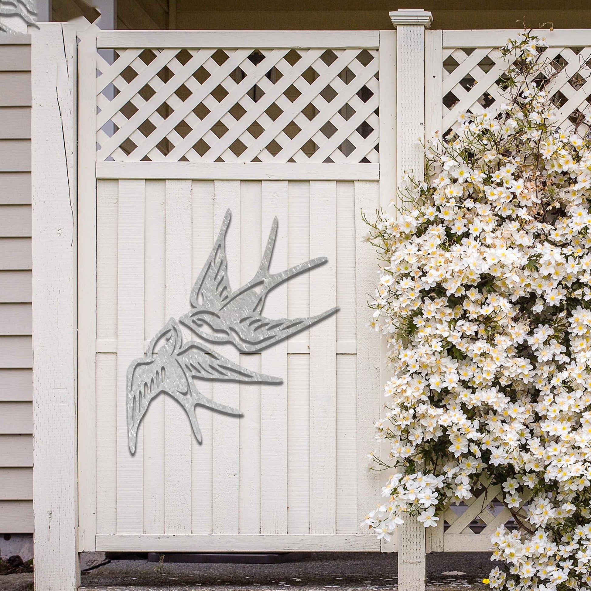 Metal garden decoration featuring a pair of swallows in flight, crafted with intricate detailing and a rustic finish, adding a graceful and timeless charm to outdoor walls or garden spaces.