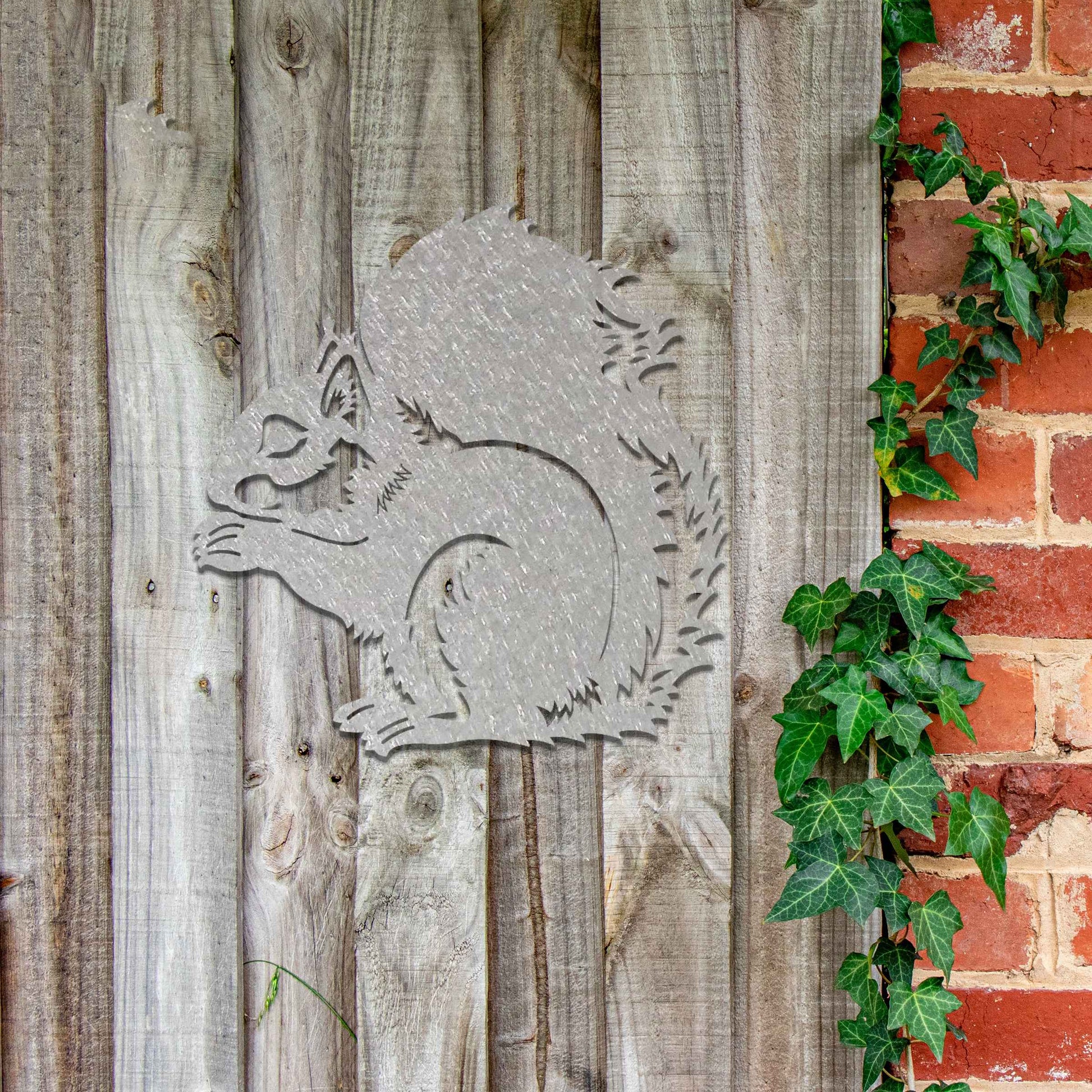 Metal garden decoration featuring a squirrel design with intricate cutout details, adding a whimsical and rustic charm to outdoor walls, blending seamlessly with natural garden surroundings.
