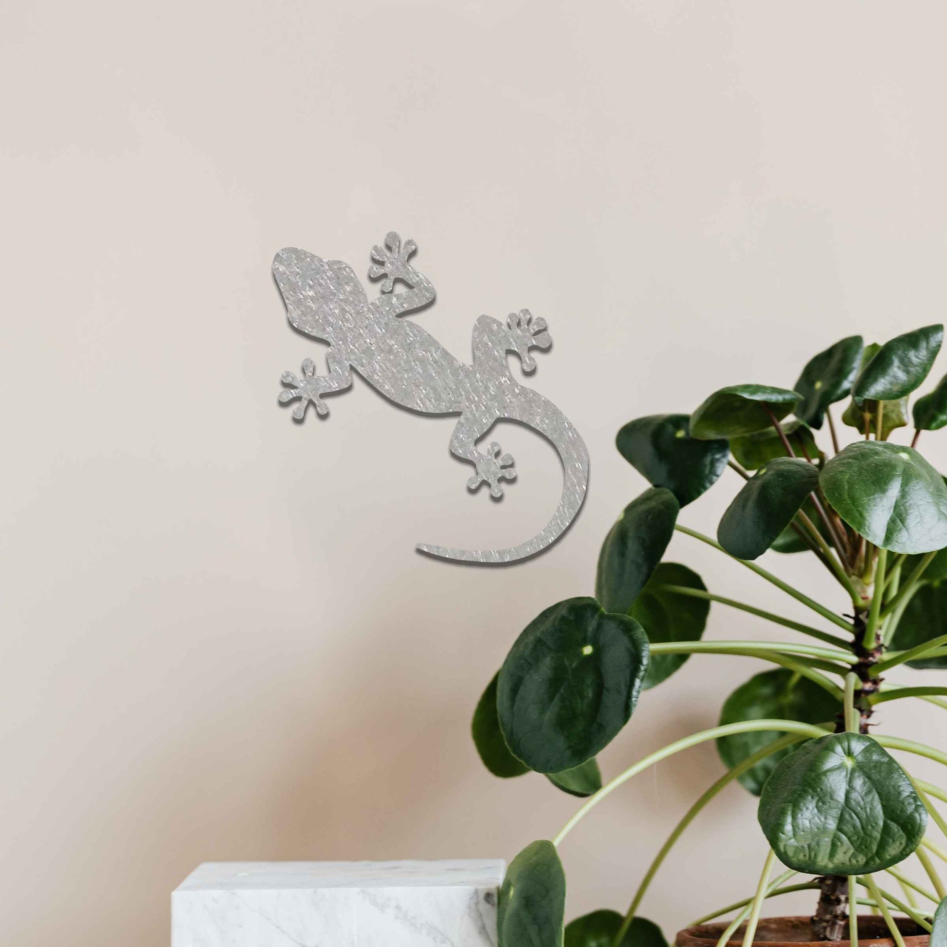Metal wall decoration featuring a simple gecko silhouette design, adding a minimalist and modern touch to indoor spaces, displayed on a neutral wall within a contemporary decor setting.