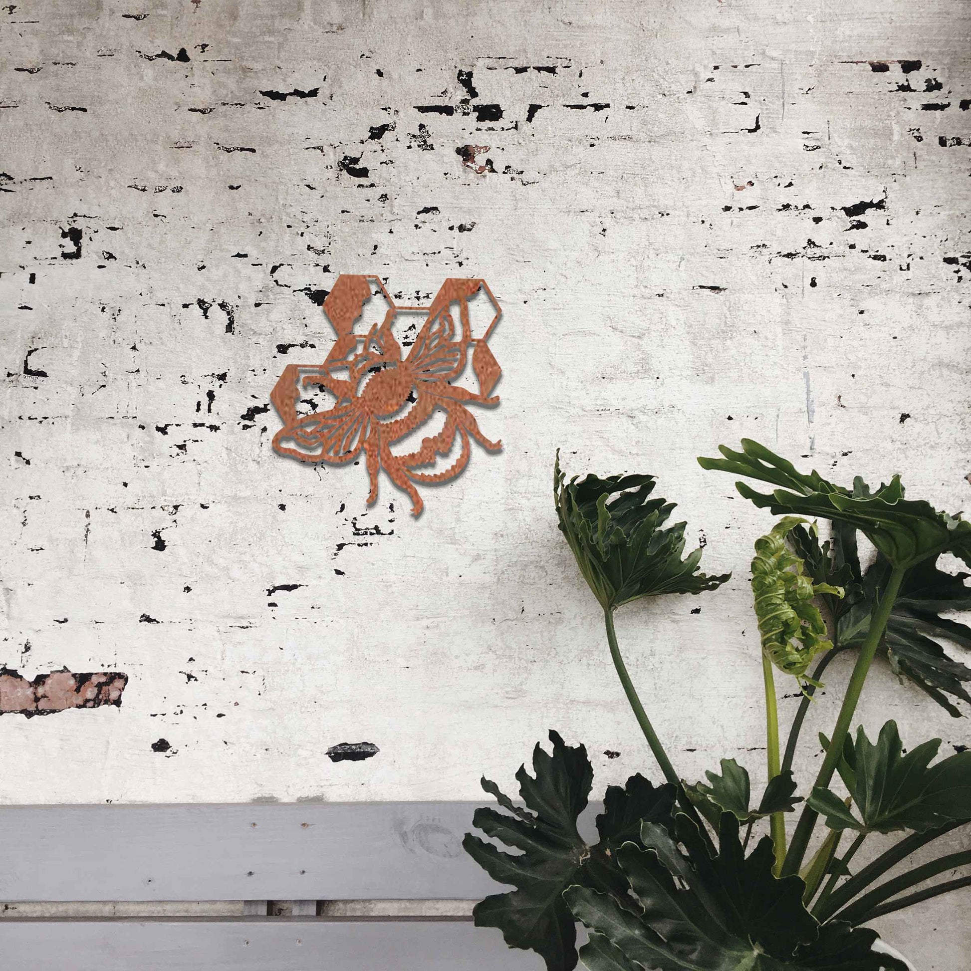 Metal garden decoration depicting a bee with honeycomb elements, intricately designed to enhance outdoor spaces, offering a blend of natural inspiration and rustic charm for garden or patio decor.