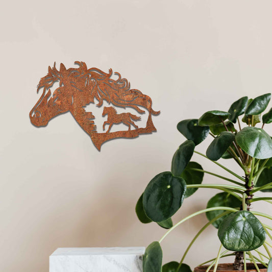 Metal wall decoration featuring a horse head silhouette with flowing mane details and a smaller horse figure within, crafted with intricate cutouts and a rustic finish, adding a majestic and artistic touch to indoor or outdoor spaces.