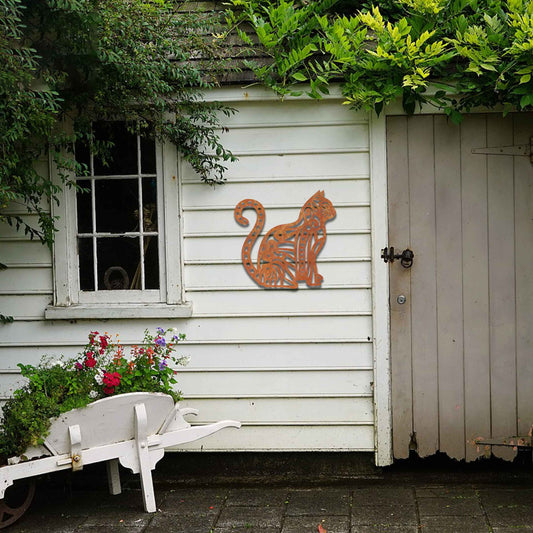 Metal garden decoration featuring a sitting cat with an intricate geometric and swirl pattern, adding a playful and artistic touch to outdoor walls or garden settings.