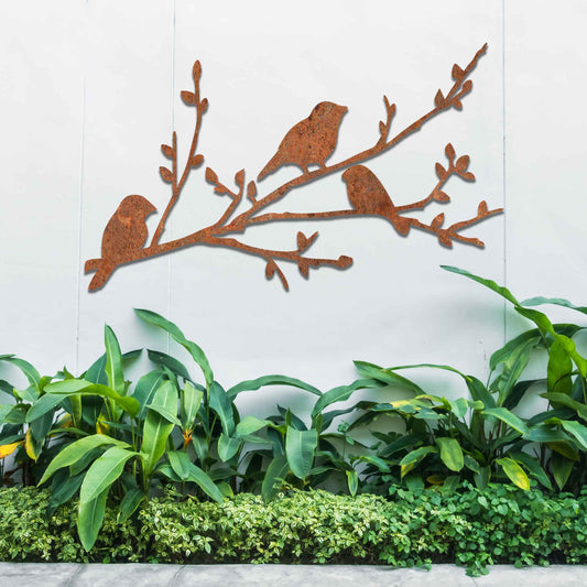 Metal garden decoration featuring three birds perched on a leafy branch, crafted with intricate cutout details and a rustic finish, adding a charming and natural touch to outdoor walls or garden spaces.