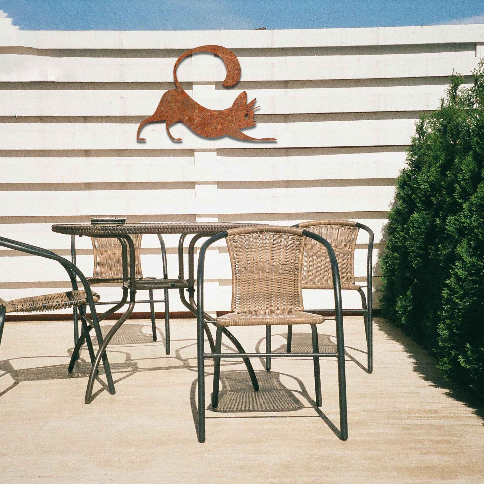Metal garden decoration featuring a playful cat stretching with its tail curved upwards, crafted with sleek and elegant detailing, adding a touch of charm and liveliness to outdoor walls, fences, or doors.
