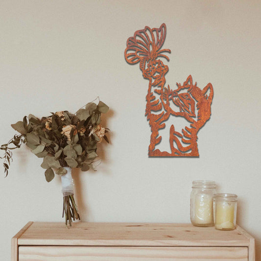 Metal wall art featuring a curious kitten playfully reaching for a butterfly, adding a delightful touch of charm and whimsy to modern indoor or outdoor decor, displayed on a neutral wall.