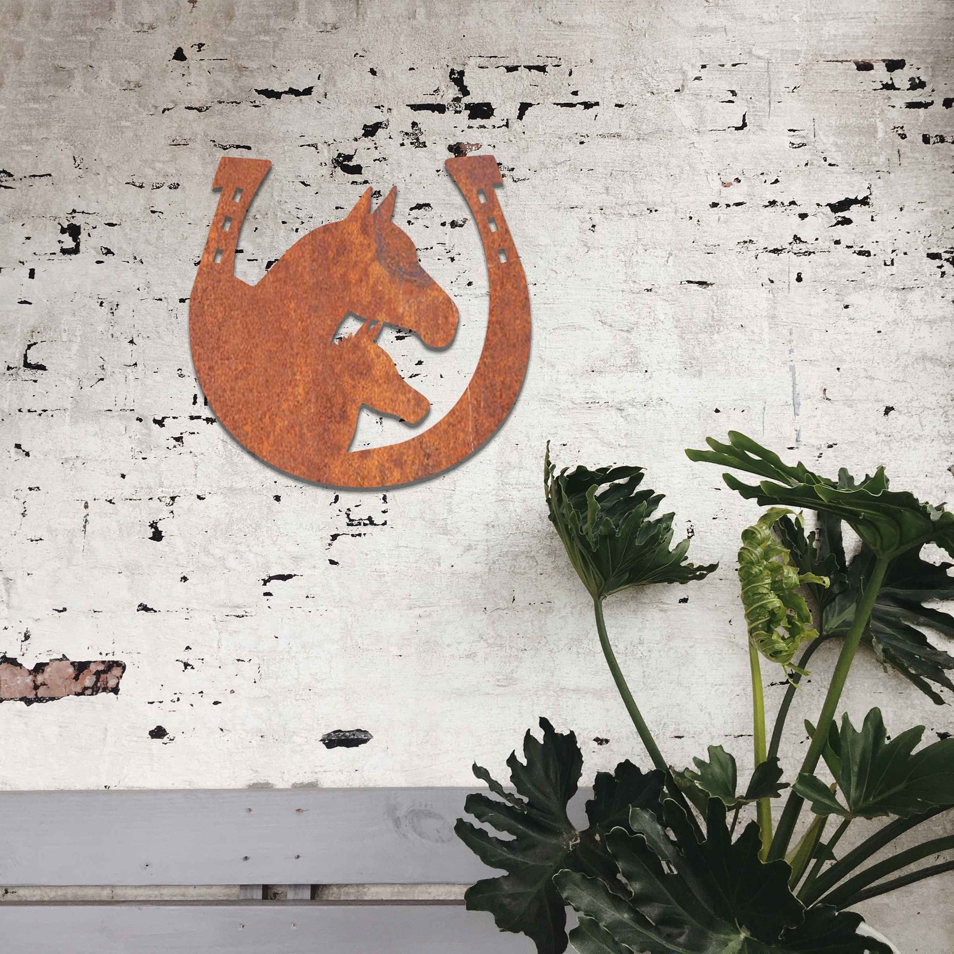 Metal garden decoration featuring a horse silhouette enclosed within a horseshoe design, crafted with a rustic finish, adding a touch of equestrian charm and character to outdoor walls or garden spaces
