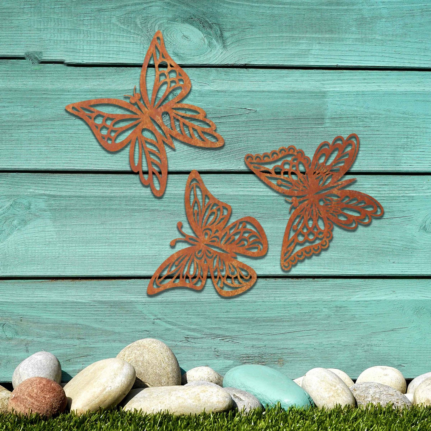 Set of metal garden decorations featuring three intricately designed butterflies with a rustic finish, adding a graceful and nature-inspired aesthetic to outdoor walls or garden spaces.