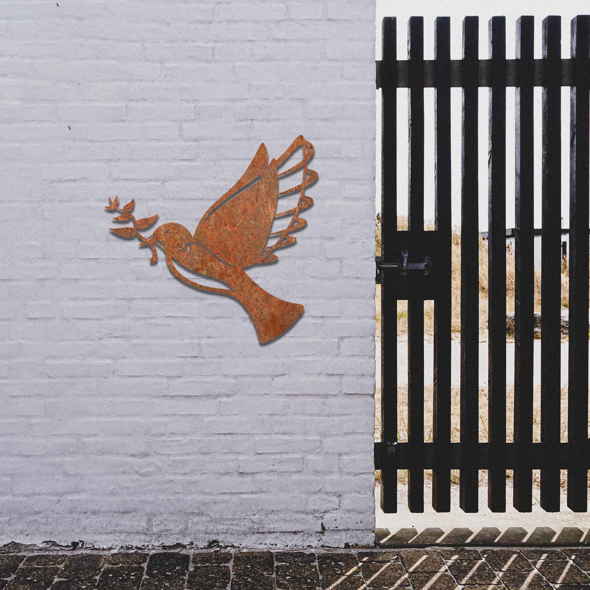 Metal garden decoration featuring a dove in flight holding an olive branch, crafted with a rustic finish, symbolising peace and harmony while adding a touch of elegance and meaning to outdoor spaces.
