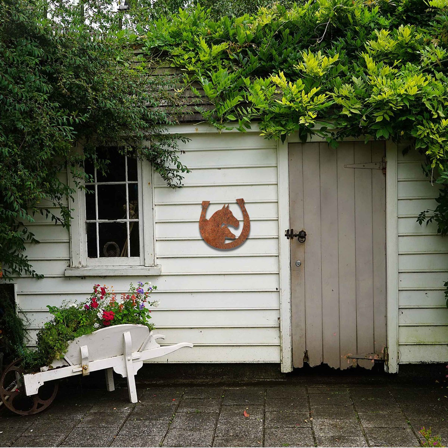 Metal garden decoration featuring a horse silhouette enclosed within a horseshoe design, crafted with a rustic finish, adding a touch of equestrian charm and character to outdoor walls or garden spaces