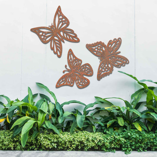 Set of metal garden decorations featuring three intricately designed butterflies with a rustic finish, adding a graceful and nature-inspired aesthetic to outdoor walls or garden spaces.