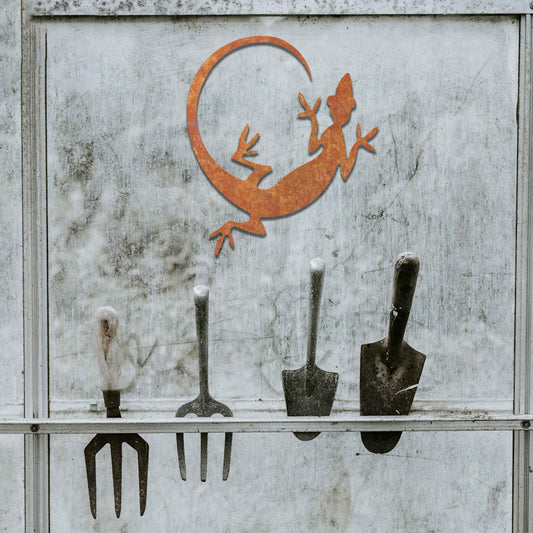 Metal garden decoration featuring a gecko silhouette design with a curved tail, adding a sleek and contemporary accent to outdoor walls, seamlessly complementing rustic and minimalist spaces.