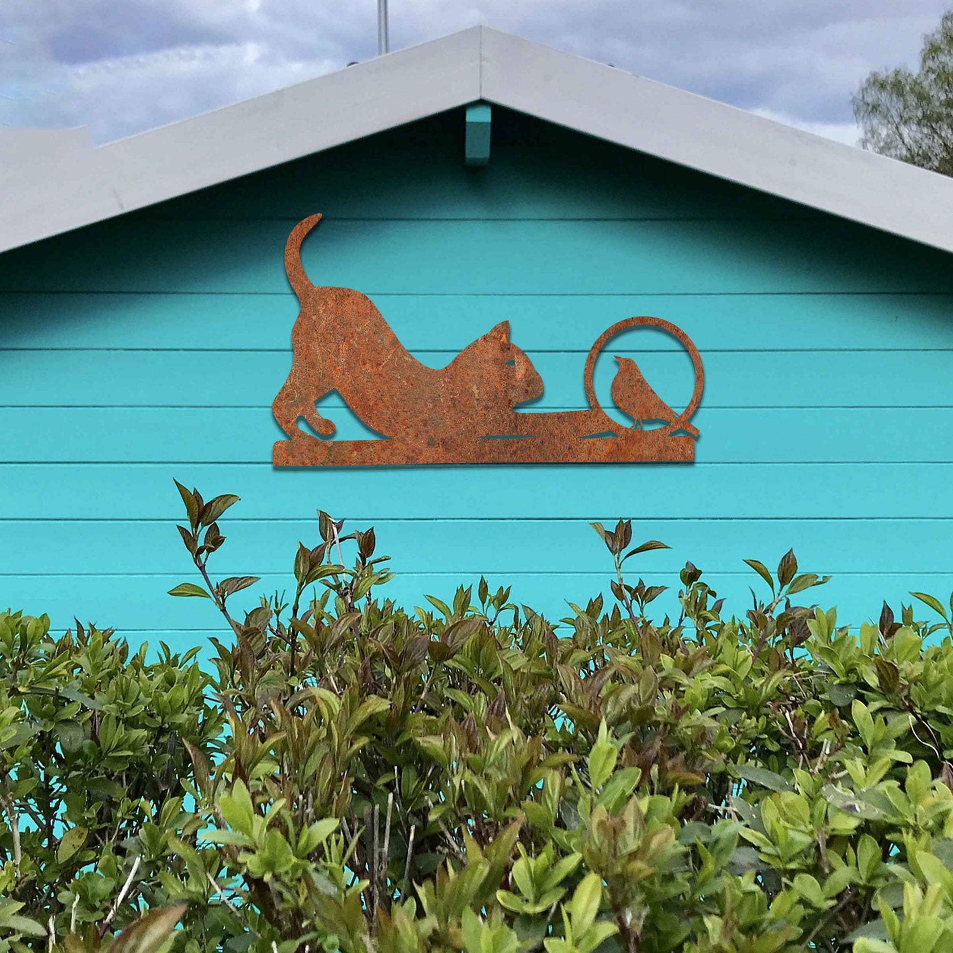 Metal wall art featuring a playful cat crouching in curiosity with a bird perched nearby, perfect for adding a touch of whimsy and nature-inspired charm to your garden, fence, or outdoor decor.