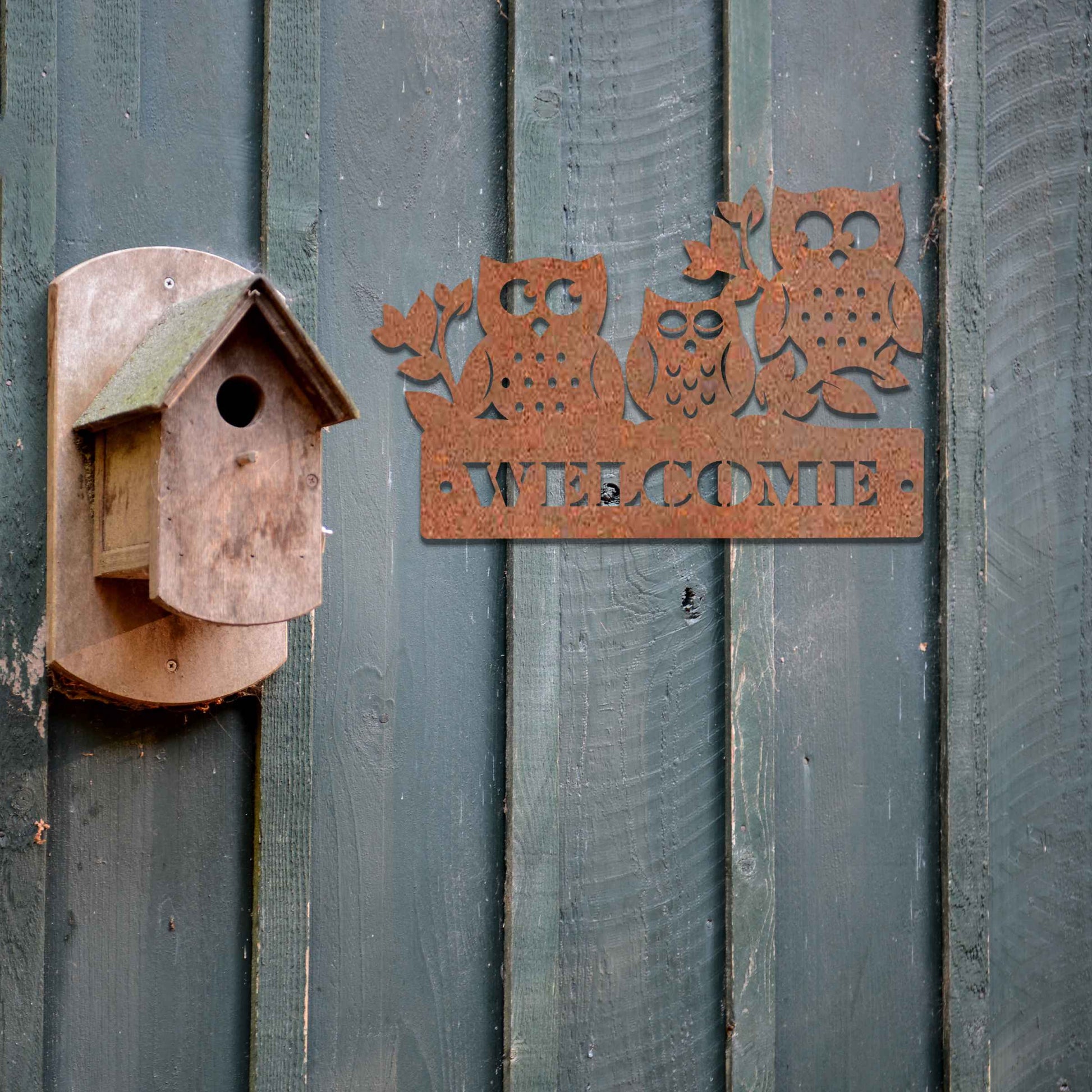 Metal garden decoration featuring three owls perched on a "Welcome" sign with a rustic finish, combining playful charm and warmth to create an inviting accent for outdoor walls, porches, or entryways.