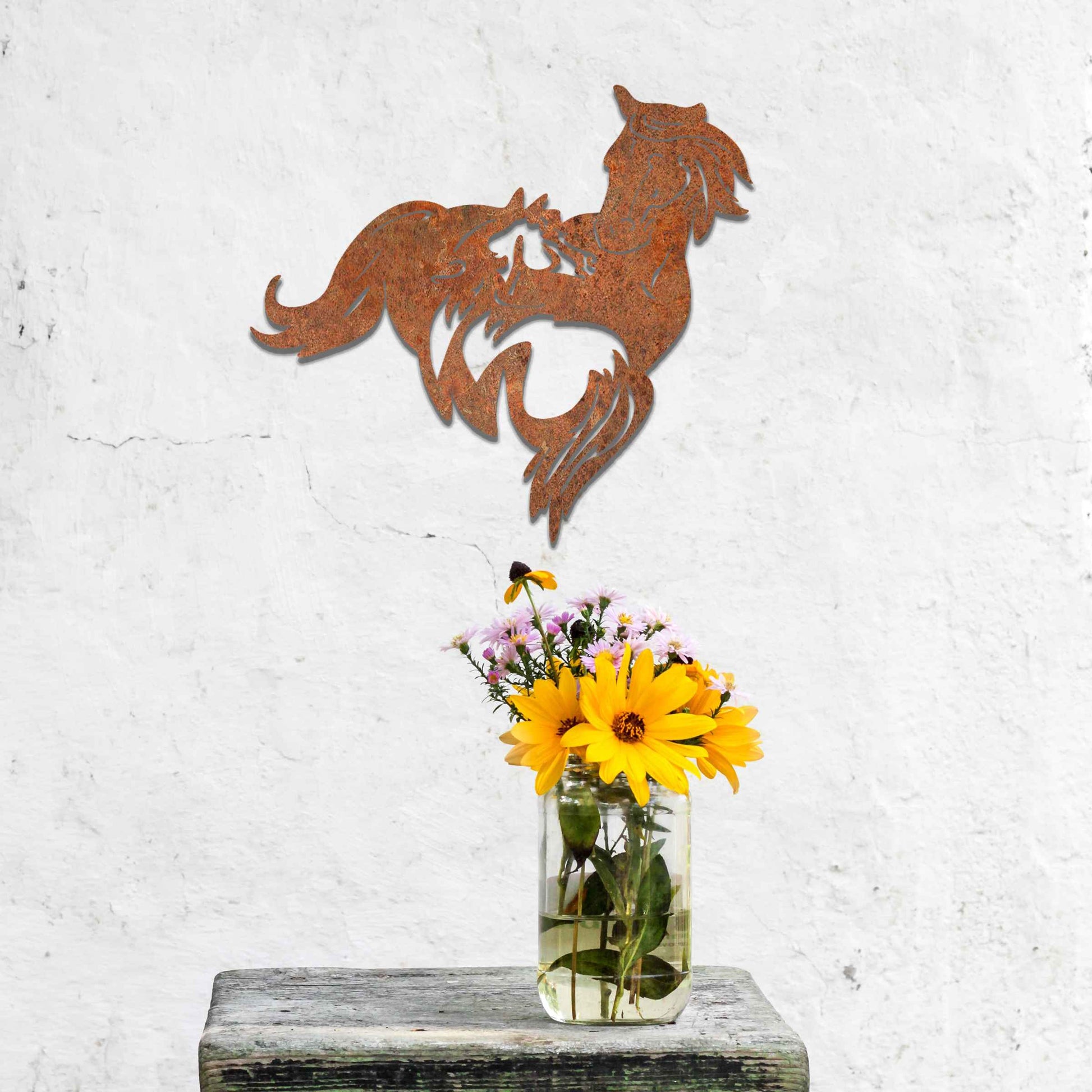 Metal wall decoration featuring a large horse with a smaller horse standing beside it, crafted with intricate cutout details and a rustic finish, adding a graceful and heartwarming touch to indoor or outdoor spaces.