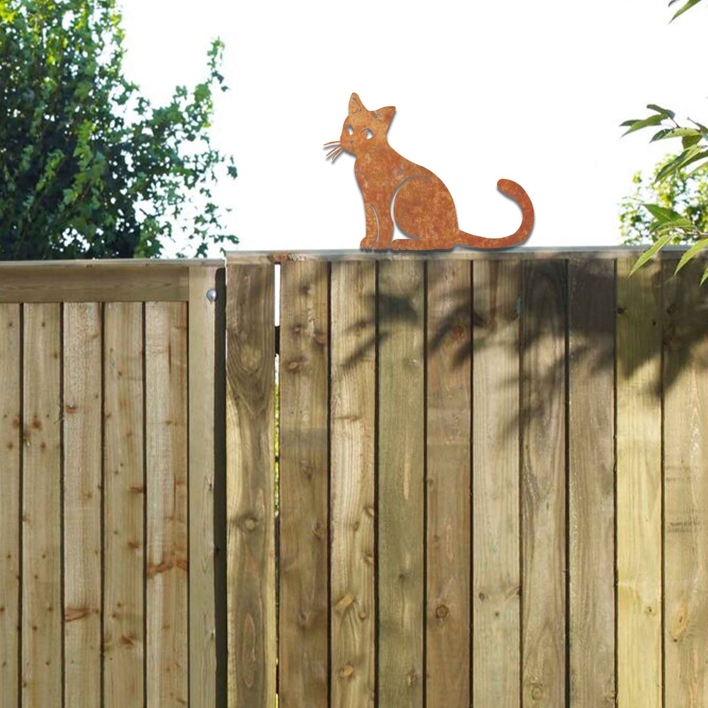 Metal garden decoration featuring a sitting cat silhouette with a rustic finish, designed to adorn fence tops or garden posts, adding a charming and playful touch to outdoor spaces.