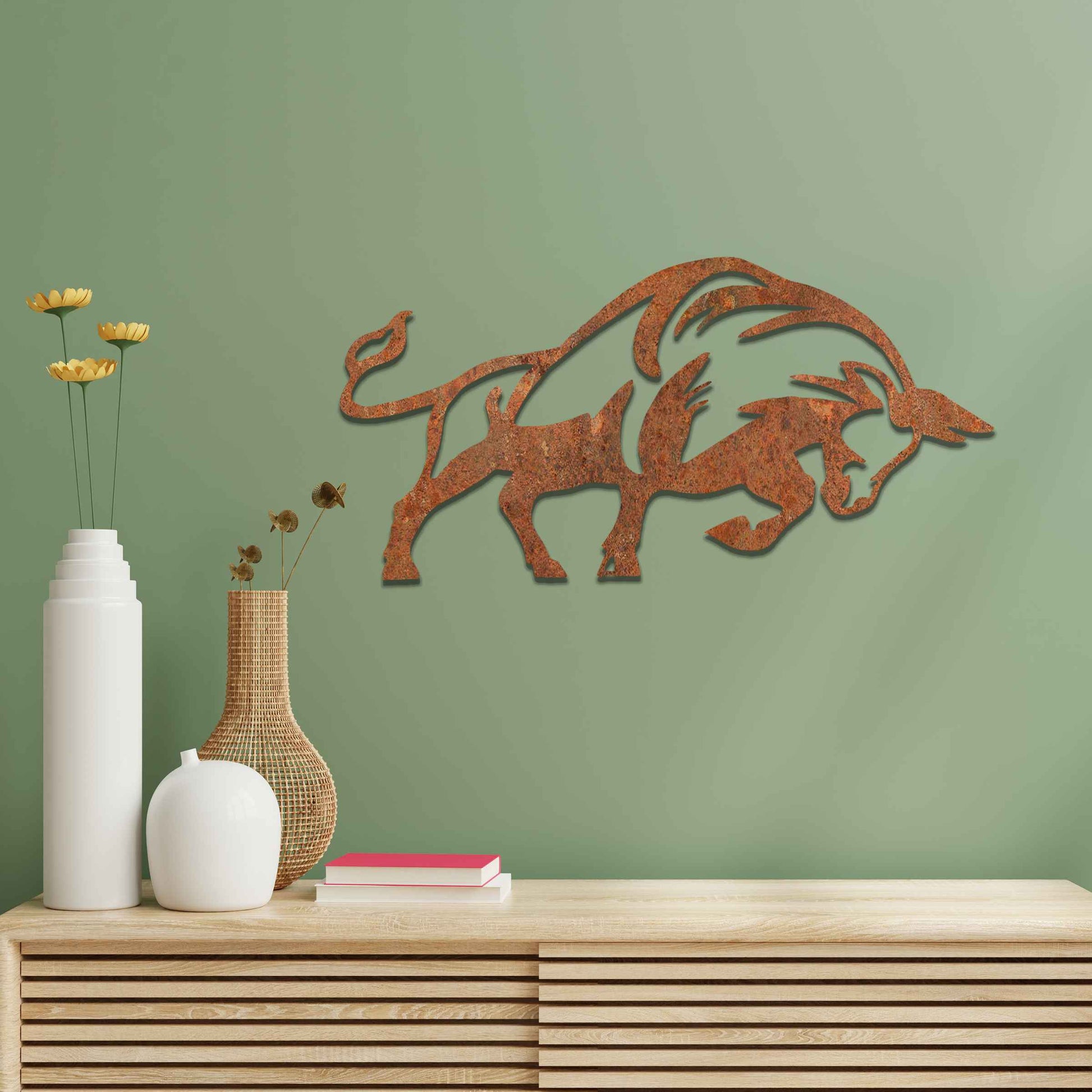 The design presents a powerful bull in motion, with strong, clean lines and a dynamic posture. The bull’s form is bold, enhanced with stylized elements that emphasize its strength. The natural rust finish adds a rugged and textured quality to the piece, accentuating its raw energy.