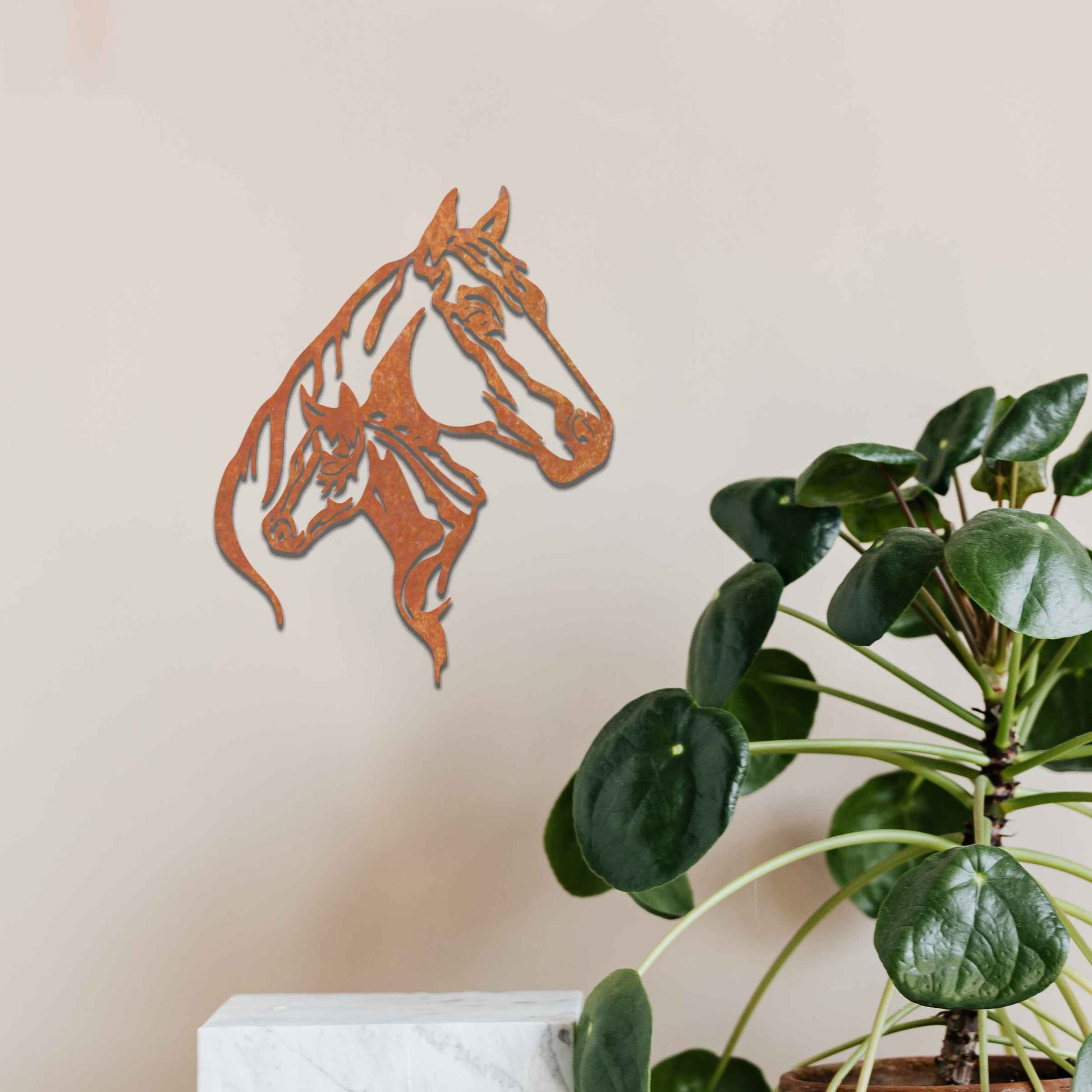 This metal wall art features two horse heads, one adult and one young, with elegant details showcasing their flowing manes and strong expressions. The design captures the connection and power of these majestic creatures.