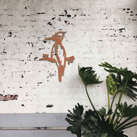 Metal garden decoration featuring a woodpecker perched on a branch, crafted with a rustic finish, adding a touch of nature-inspired charm and elegance to outdoor walls or garden settings.