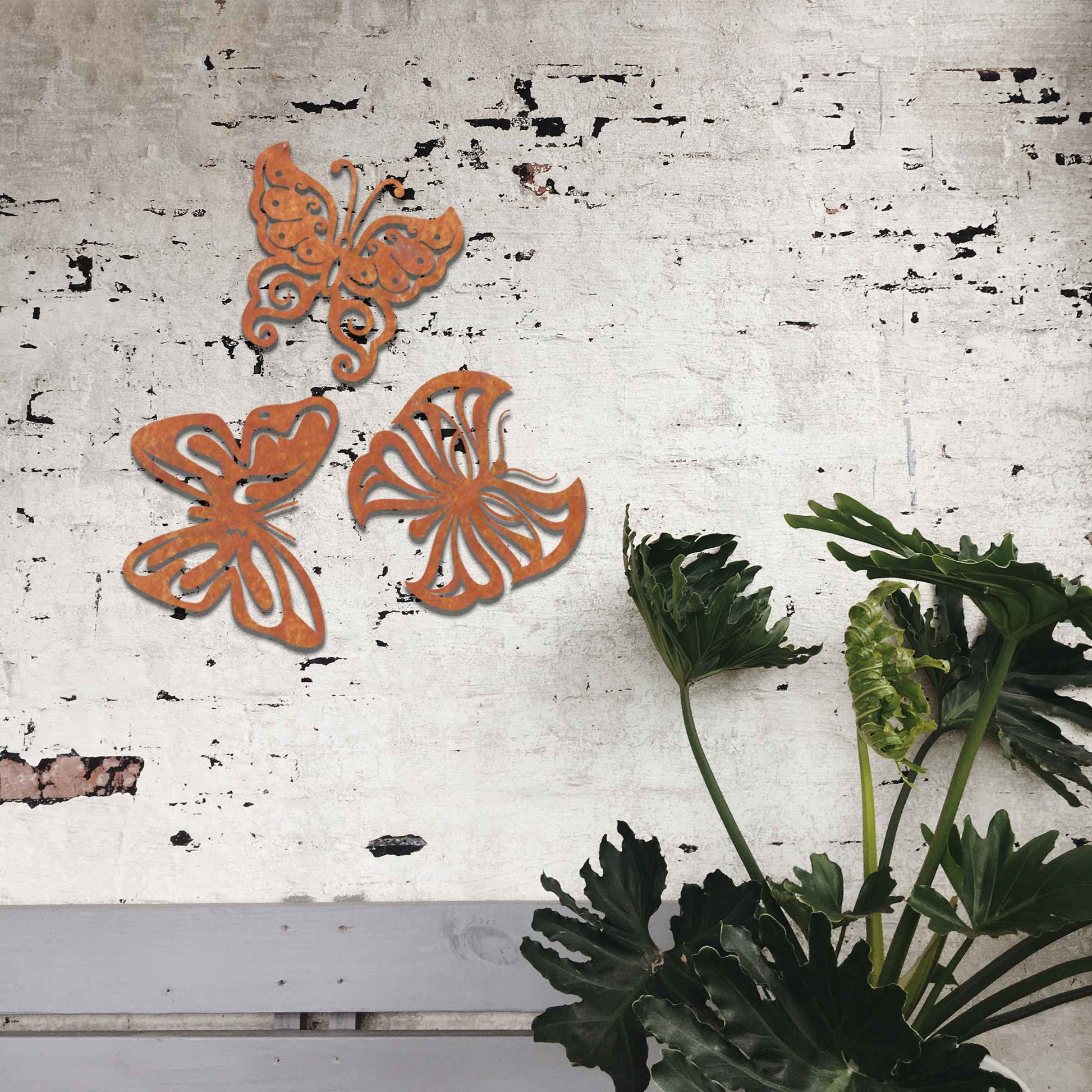 Set of metal garden decorations featuring three distinct butterfly designs with intricate patterns, adding a playful and nature-inspired charm to outdoor walls, fences, or garden spaces