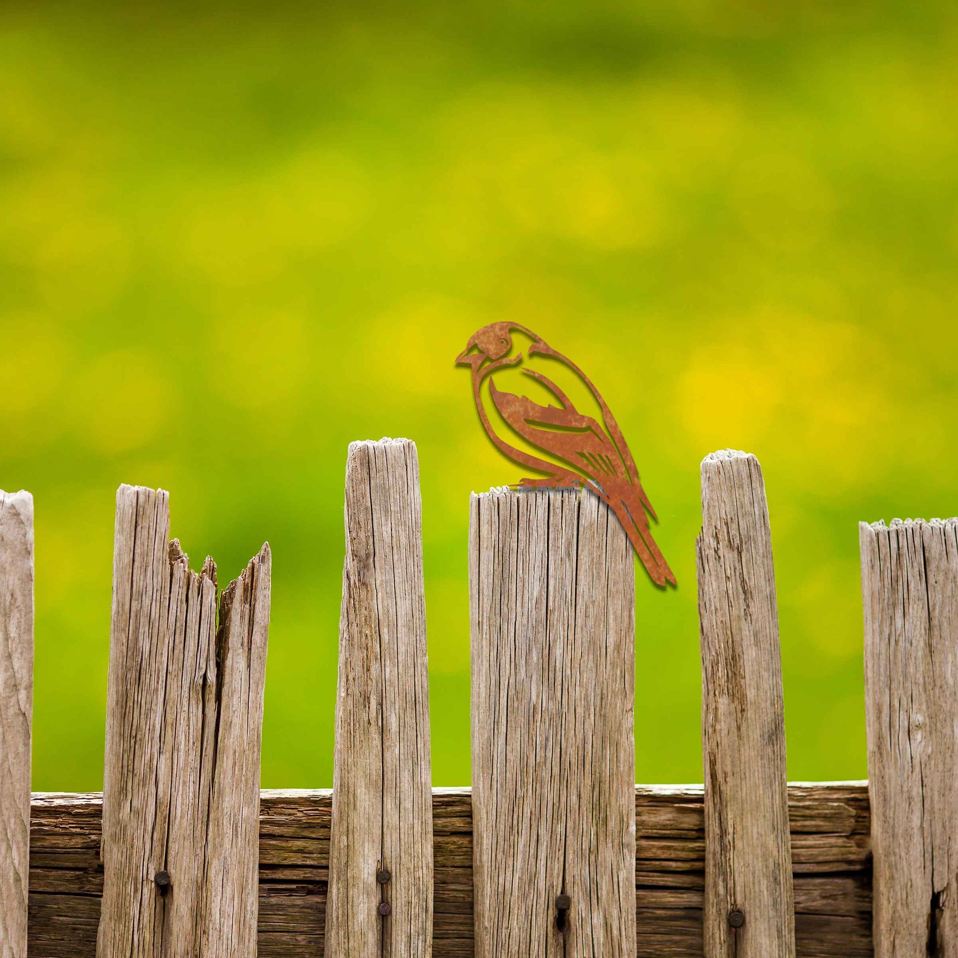 Metal garden decoration featuring a swallow silhouette with intricate cutout details and a rustic finish, designed to perch elegantly on wooden fences, adding a graceful and natural touch to outdoor spaces.