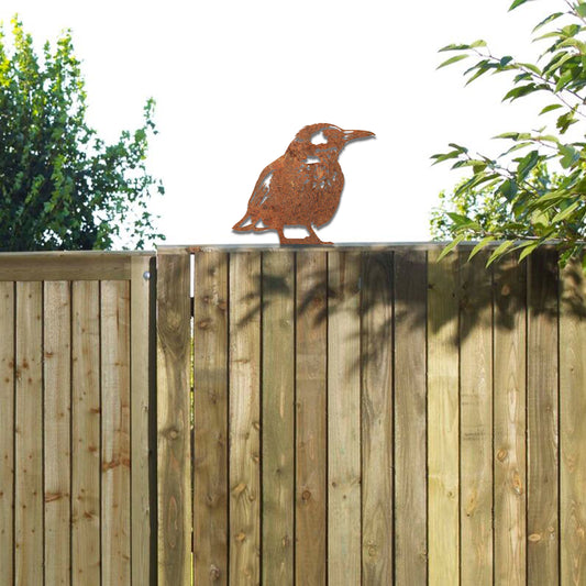 Metal wall art of a bird perched on a wooden fence post, featuring detailed wing and feather patterns. The bird is in a relaxed pose, surrounded by sunflowers, showcasing nature's beauty.