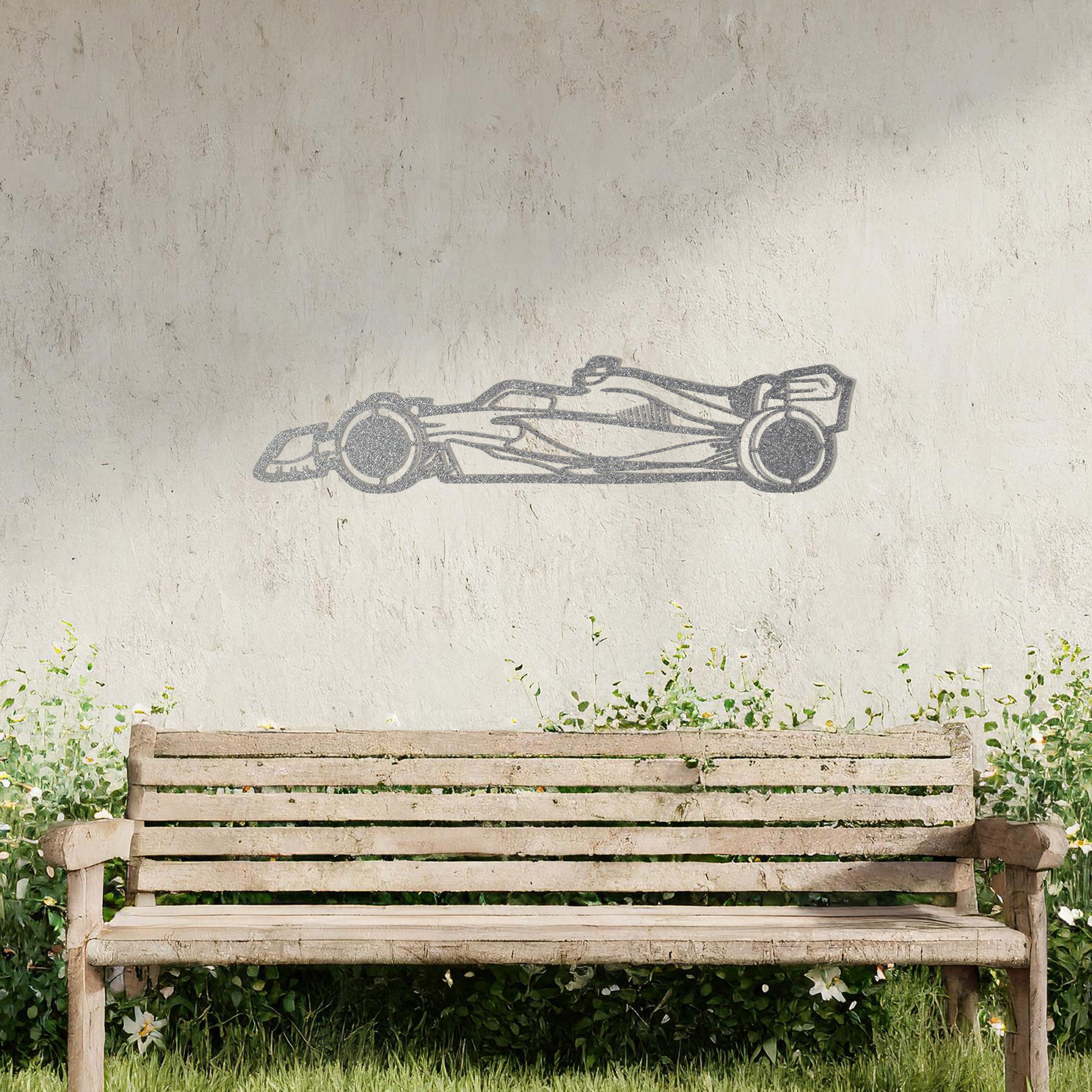 A sleek metal wall art design showcasing a detailed Formula 1 car silhouette. Perfect for motorsport enthusiasts, this artwork brings dynamic energy to modern or contemporary spaces. It is displayed on a neutral wall in a stylish outdoor setting.