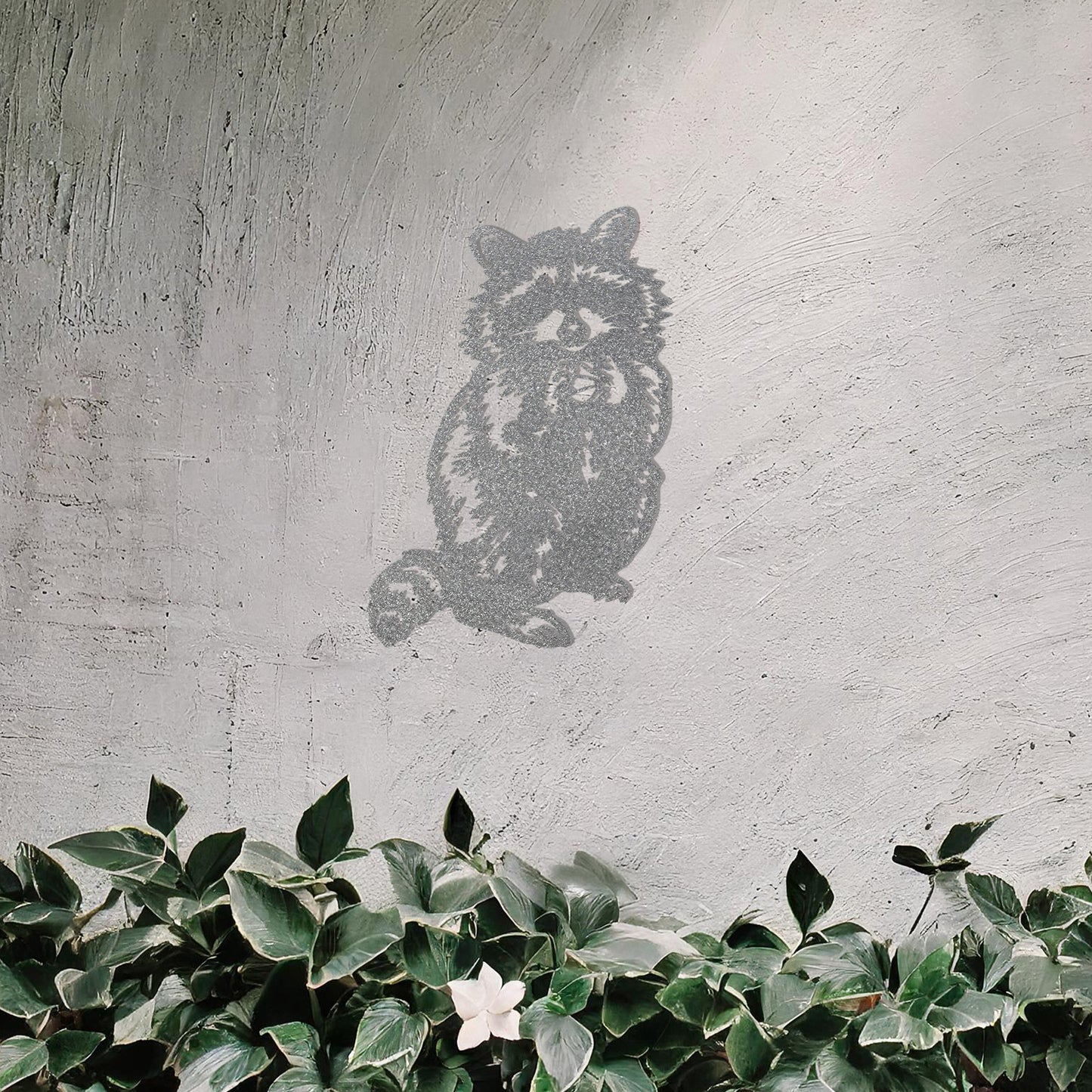 A metal wall art piece featuring a detailed raccoon design, evoking charm and playfulness. This adorable artwork adds a whimsical touch to modern or rustic settings, harmonising beautifully with natural decor elements.