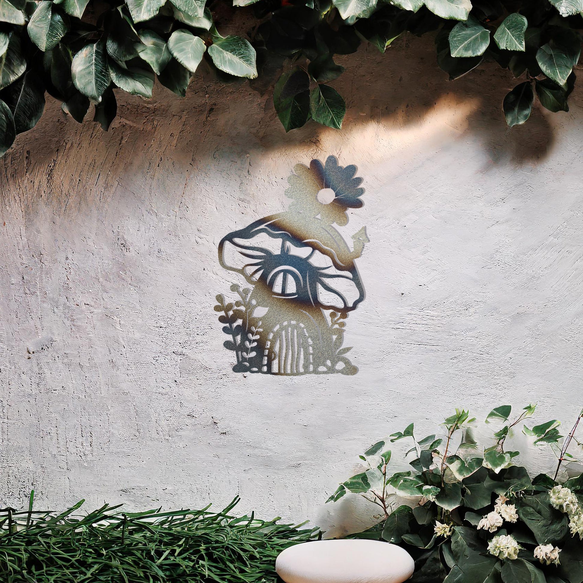 This piece depicts a whimsical mushroom house with a flower on top, surrounded by plants. Its enchanting design, perfect for garden or indoor decor, adds charm to any space with its delightful details.