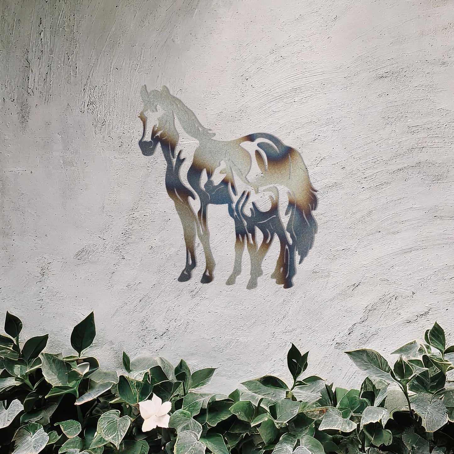 A stunning metal wall art design featuring two horses, showcasing a larger horse and a smaller one standing together, symbolising grace and unity. This artwork adds an elegant touch to a neutral wall in a beautifully styled outdoor space.