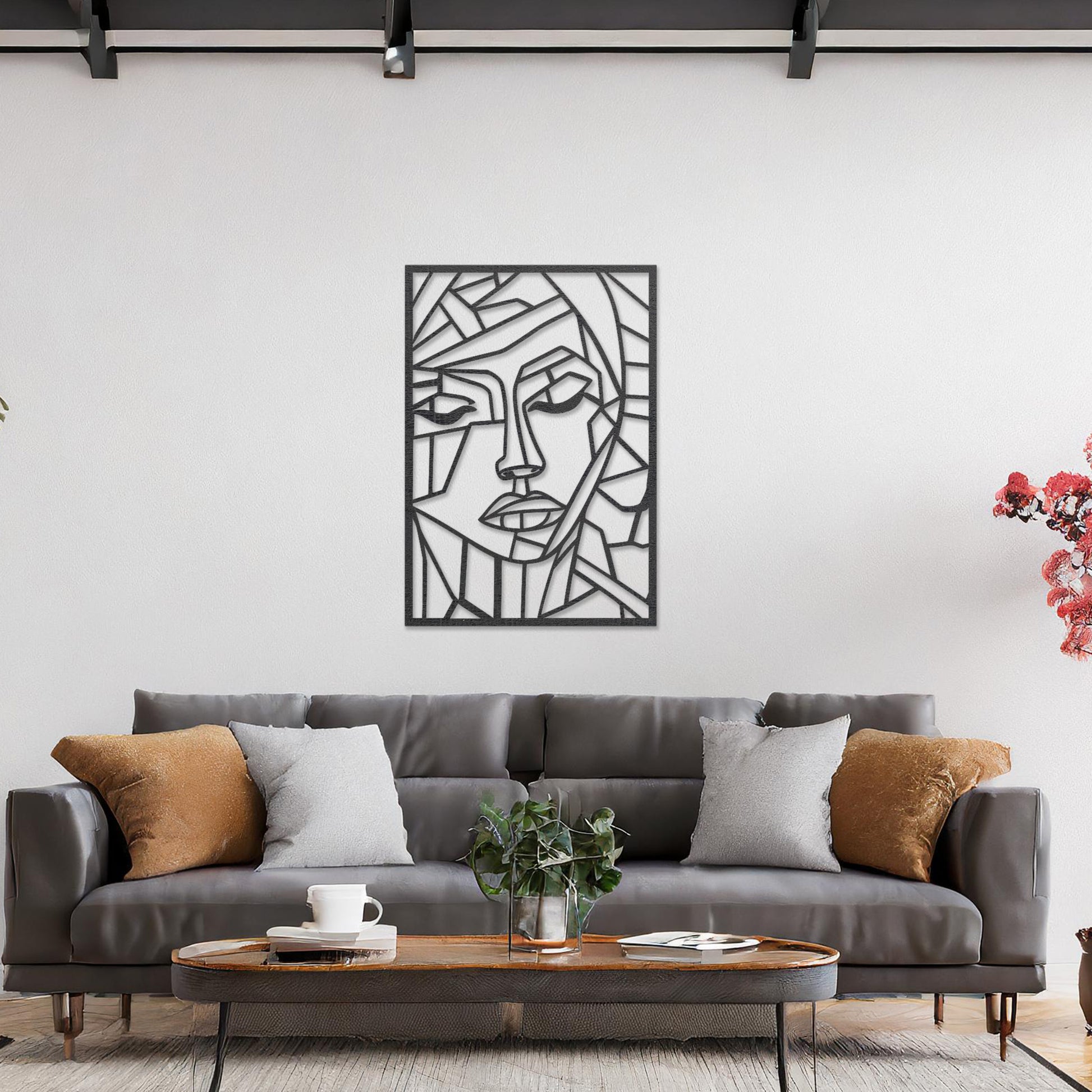 A rectangular wall art piece featuring an abstract face design composed of geometric shapes and clean lines. The artwork is displayed on a neutral wall in a contemporary living room, 
