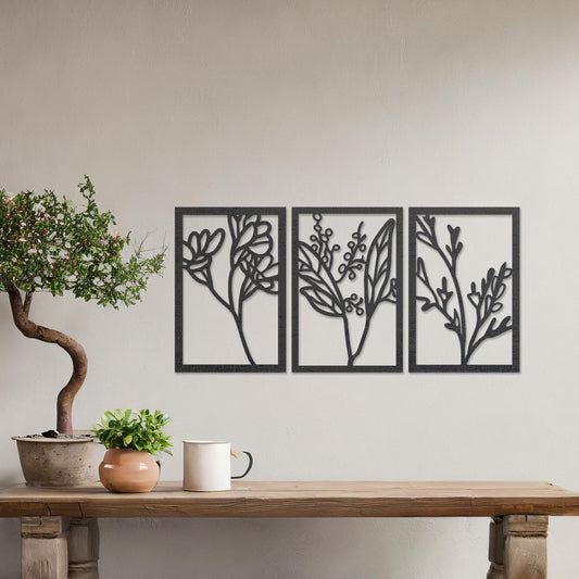 Wall art featuring a triptych of minimalist botanical designs, each panel highlighting delicate stems, leaves, and berries. The artwork is displayed on a neutral wall within modern decor, adding a subtle and natural elegance to the space.