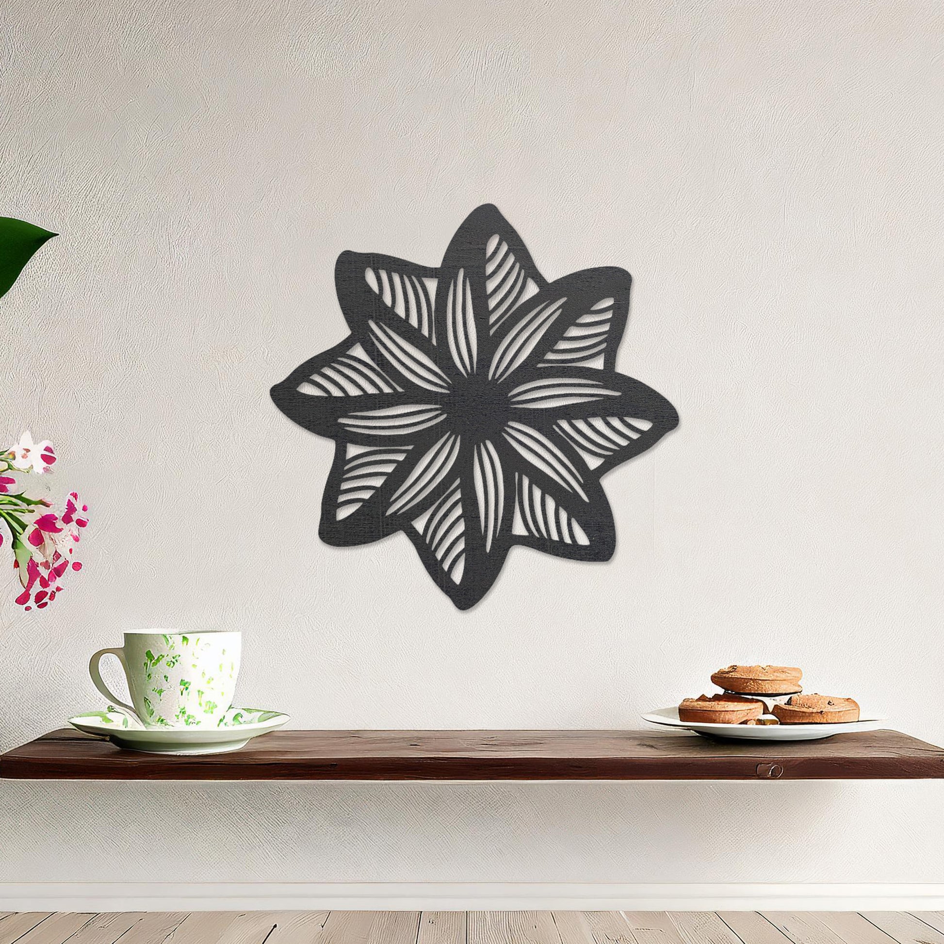Wall art featuring a star-shaped floral design with layered petals and intricate cut-out patterns. The piece is displayed on a neutral wall within modern decor, adding a unique and decorative focal point to the space.