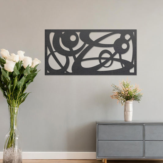 Wooden wall art design featuring an abstract composition of flowing lines and circular shapes, placed on a neutral wall within modern room decor. The design combines dynamic curves and geometric forms for a contemporary, artistic feel.