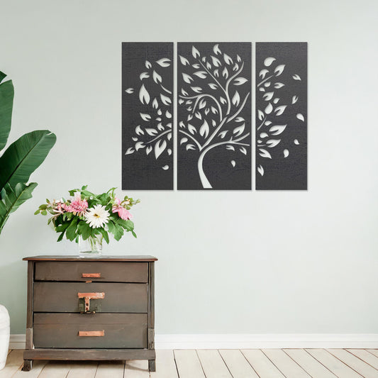 Wooden wall art consisting of three panels featuring a flowing tree design with scattered leaves, displayed on a neutral wall within modern room decor, emphasising its elegant and natural aesthetic.