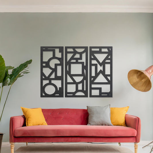 This image features a vibrant, modern triptych wall art design made of geometric shapes and patterns. The bold black designs contrast against a light green wall, complementing the stylish sofa below. 