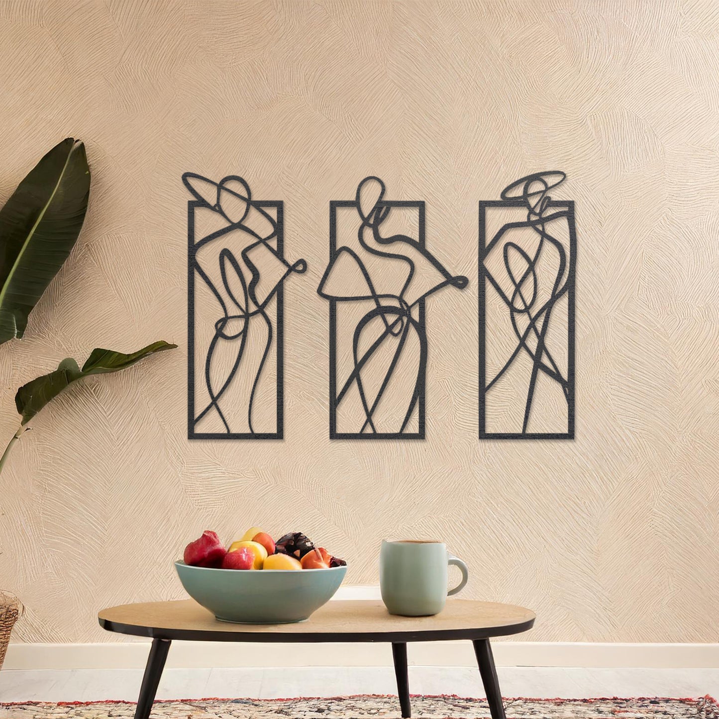 Wooden wall art design featuring three abstract figures in flowing lines, each in its own rectangular frame, placed on a neutral wall with modern room decor. The design evokes movement and elegance through minimalistic, artistic shapes.