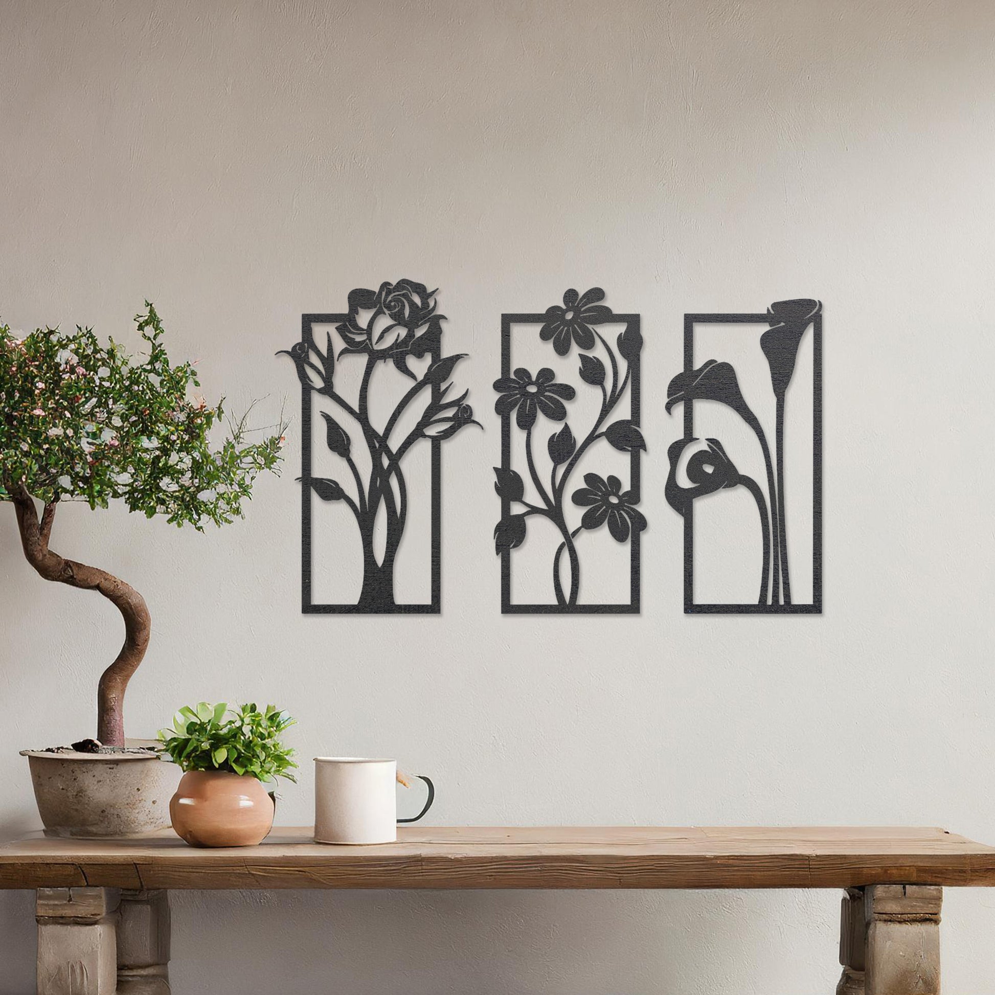 Wall art featuring a triptych of floral designs, each panel showcasing distinct flowers such as roses, daisies, and calla lilies. The artwork is displayed on a neutral wall within modern decor, adding a natural and elegant touch to the space.