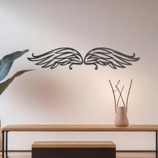 Wall art featuring a pair of intricately designed angel wings with flowing lines and graceful curves. The piece is displayed on a neutral wall within modern decor, adding a symbolic and elegant touch to the setting.