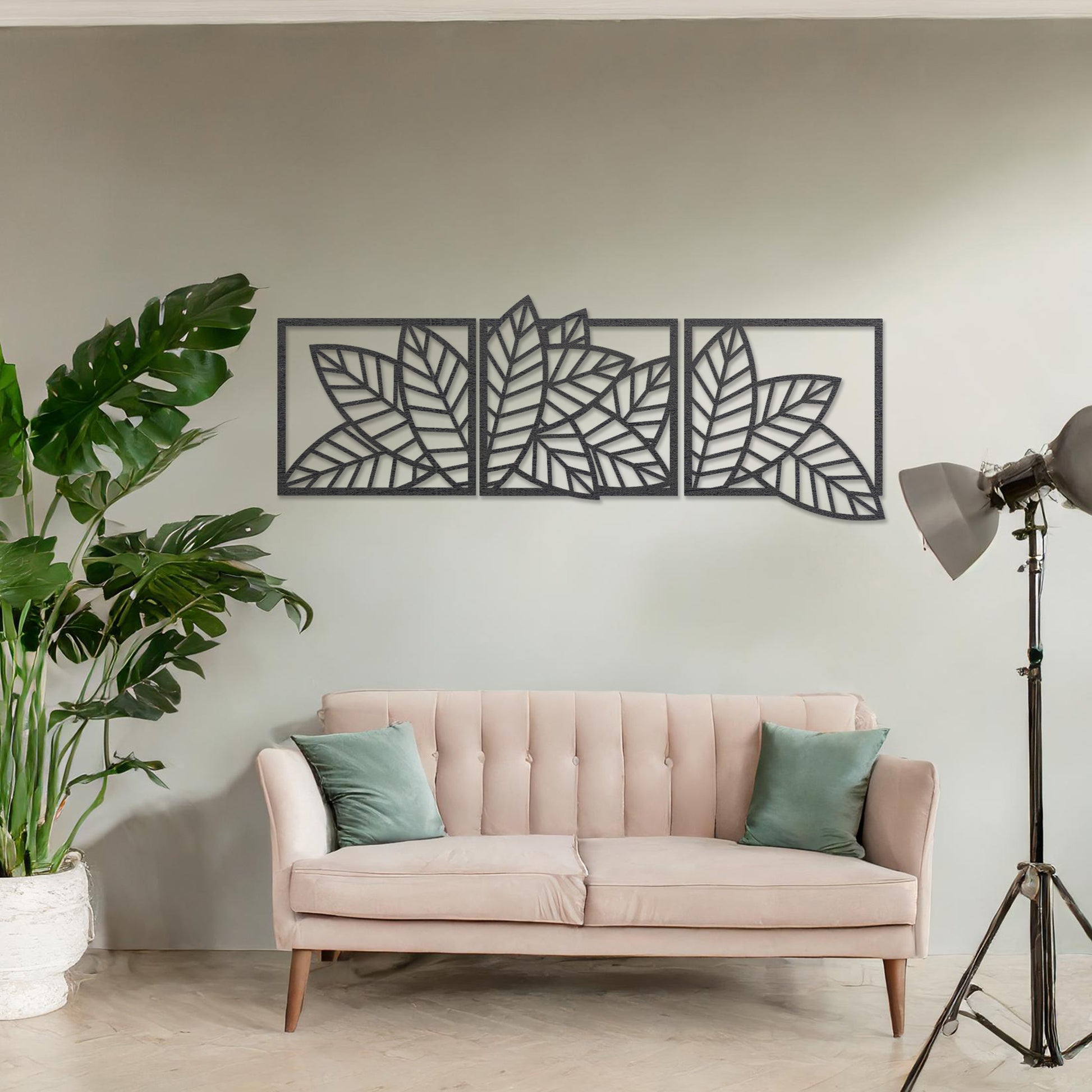 Wooden wall art featuring a three-panel design of overlapping leaf patterns with intricate cut-outs. The artwork is displayed on a neutral wall within modern room decor, highlighting its natural and elegant design.